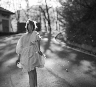 Photo floue d'une fille courant avec un pissenlit en main